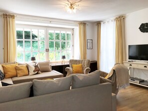 A living room with a sofa, armchairs, a television, and a window with curtains. - Family-friendly home for 10 persons, big garden, Fireplace, 4 km ski carousel. (Winterberg)