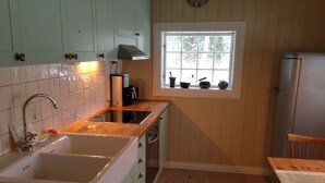A kitchen with a sink, stove, and window.