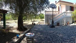 A courtyard with a basketball hoop, a stone floor, and a staircase leading to a building. - 'Absolutely great holiday home with a large garden near the beach' (Policastro Bussentino)