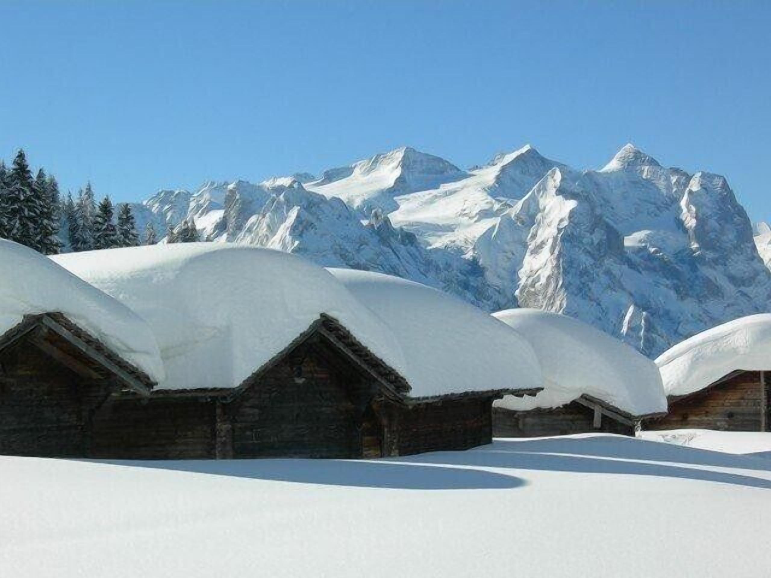 Un paysage montagneux enneigé avec des chalets en bois.