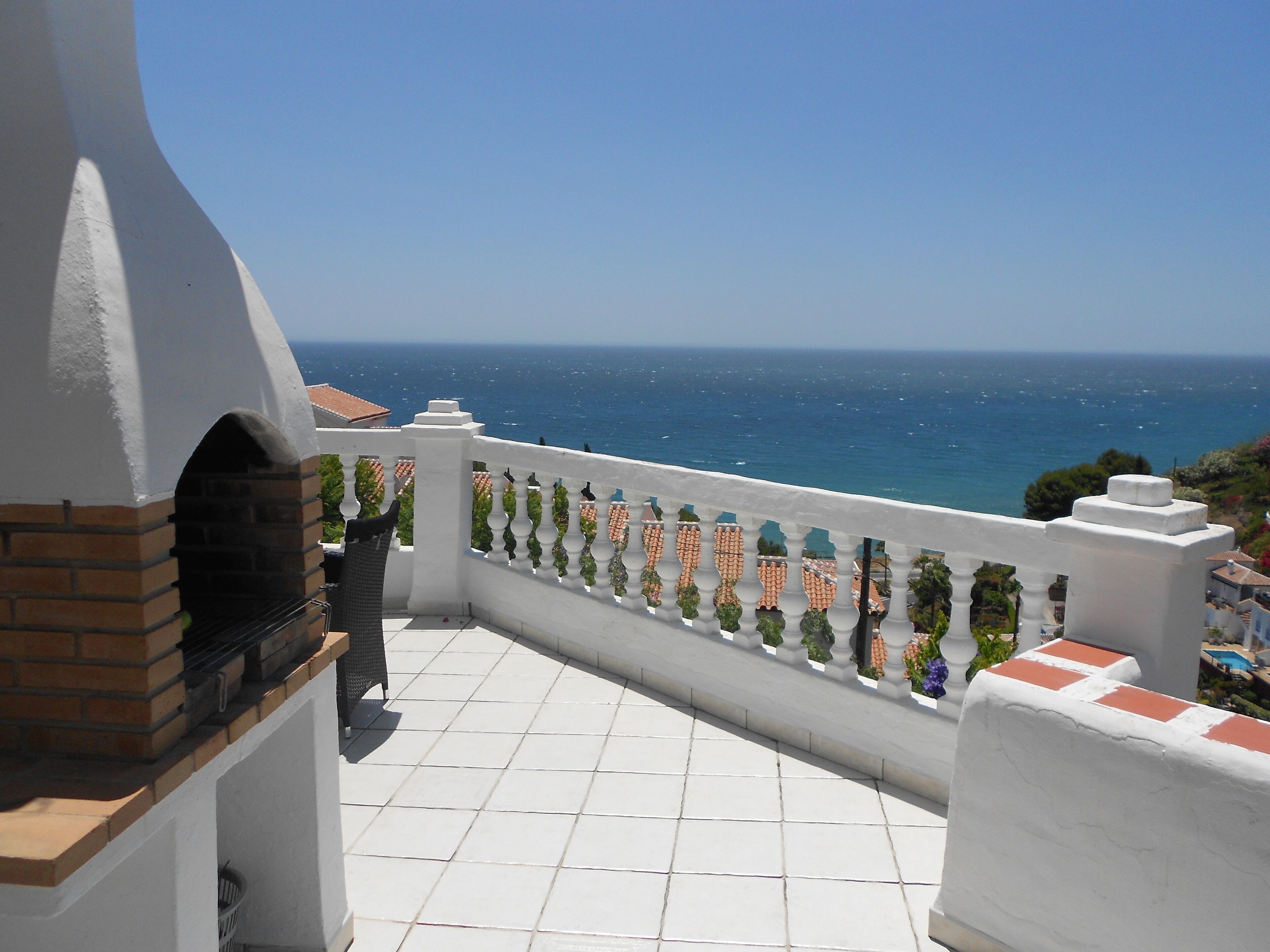 Ein Balkon mit Meerblick, ein Backofen und ein Fliesenboden.