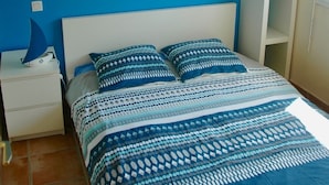 Une chambre à coucher avec un lit, des murs bleus et une tête de lit blanche.