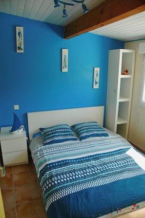 Une chambre à coucher avec un lit, une table de chevet et une armoire blanche.