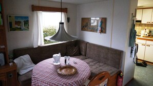 Una habitación acogedora con una mesa redonda, un sofá y una kitchenette.