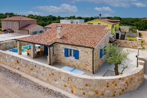 A stone building with a tiled roof, a swimming pool, and a small tree. - Warm, sunny, private and family friendly villa, where pets are welcome (Svetvinčenat)