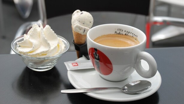 A cup of coffee with whipped cream and a scoop of ice cream on a saucer. - Apartment only 600 m. from the beach, with sunny balcony on the south! (Nordholland)