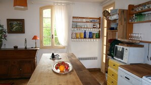 Une cuisine avec des meubles de rangement en bois, un four à micro-ondes et une assiette de fruits sur le comptoir.