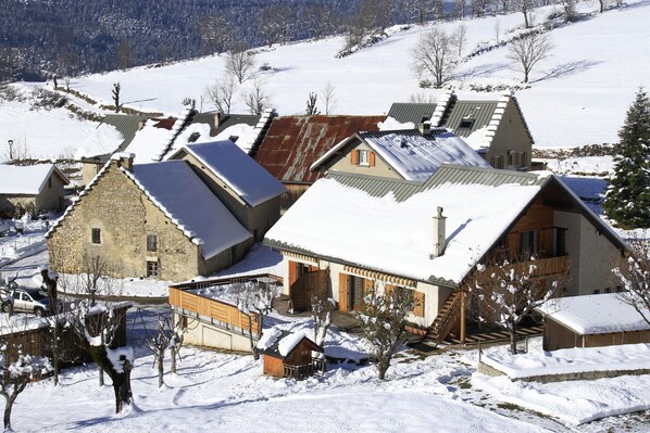 A snow-covered village with traditional stone houses and wooden structures. - Comfortable and well-kept Vercors house, made beds, closed garage & Wifi (Villard-De-Lans)