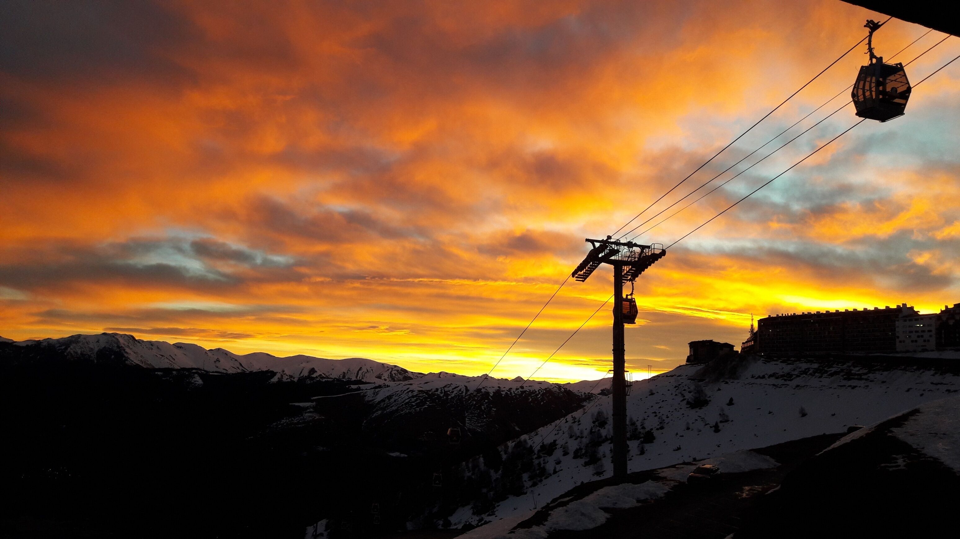 A cable car system against a sunset sky.