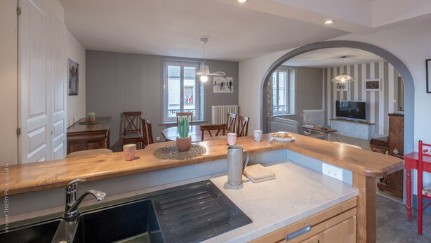 Een moderne keuken met een houten aanrecht, een spoelbak en een eethoek met stoelen en een tafel.