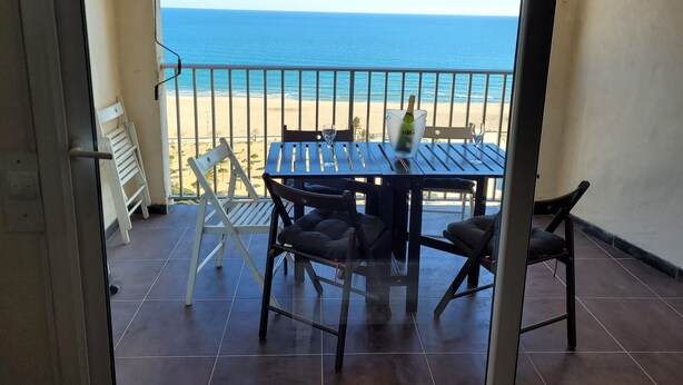 A balcony with a table, chairs, and a view of the beach. - YOU Escape IN BAY OF Roses, ONE OF THE Most Beautiful World! (EMPURIABRAVA)