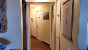 A narrow hallway with wooden flooring, white walls, and doors leading to rooms. - YOU Escape IN BAY OF Roses, ONE OF THE Most Beautiful World! (EMPURIABRAVA)