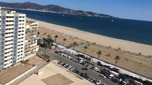 A coastal cityscape with a beach, a parking lot, and a high-rise building. - YOU Escape IN BAY OF Roses, ONE OF THE Most Beautiful World! (EMPURIABRAVA)
