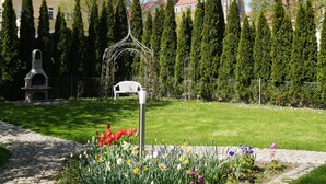 A garden with a gazebo, a bench, and a metal sculpture.