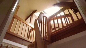 A wooden staircase with a view of the upper floor.