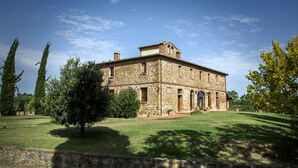 A stone building with a central courtyard, surrounded by trees and a clear sky. - Apartment with terrace and enchanting view (Torrita di Siena)