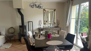 Een eetgedeelte met een tafel, stoelen, een spiegel en een open haard.