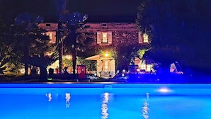 Ein Blick auf einen Poolbereich bei Nacht, im Hintergrund ein Gebäude.
