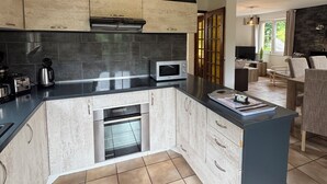 A modern kitchen with a central island, built-in appliances, and a hanging pendant light.
