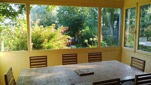 A sunlit room with a large window overlooking a garden. - 4* villa with beautiful garden - 2 to 10 people (Bangor)