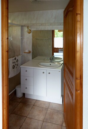 Ein Badezimmer mit zwei Waschbecken, einer Toilette und einer Dusche.