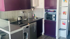 A compact kitchen with a washing machine, a microwave, and a small refrigerator. - STUDIO RENOVATED WITH VIEW ON BOATS FOR 4 PEOPLE (Agde)
