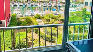 A balcony with a view of a marina and colorful buildings. - STUDIO RENOVATED WITH VIEW ON BOATS FOR 4 PEOPLE (Agde)