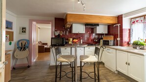 A kitchen with a dining area, wooden cabinets, a microwave, and a toaster.