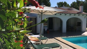 A poolside area with lounge chairs and a covered patio.