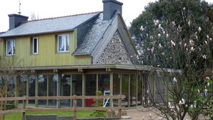 A two-story house with a stone facade and a wooden deck. - country house in Plestin les Grèves (Plestin-Les-Grèves)