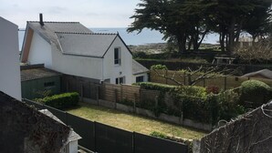 A white house with a sloped roof and a fenced yard.