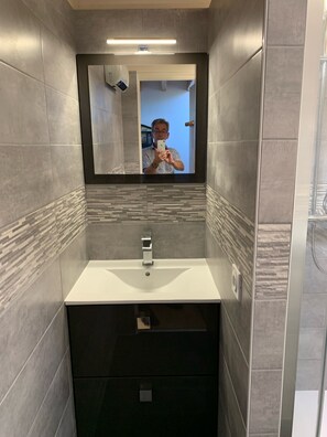 Une salle de bain moderne avec un miroir, un lavabo et un meuble-lavabo doté de tiroirs.