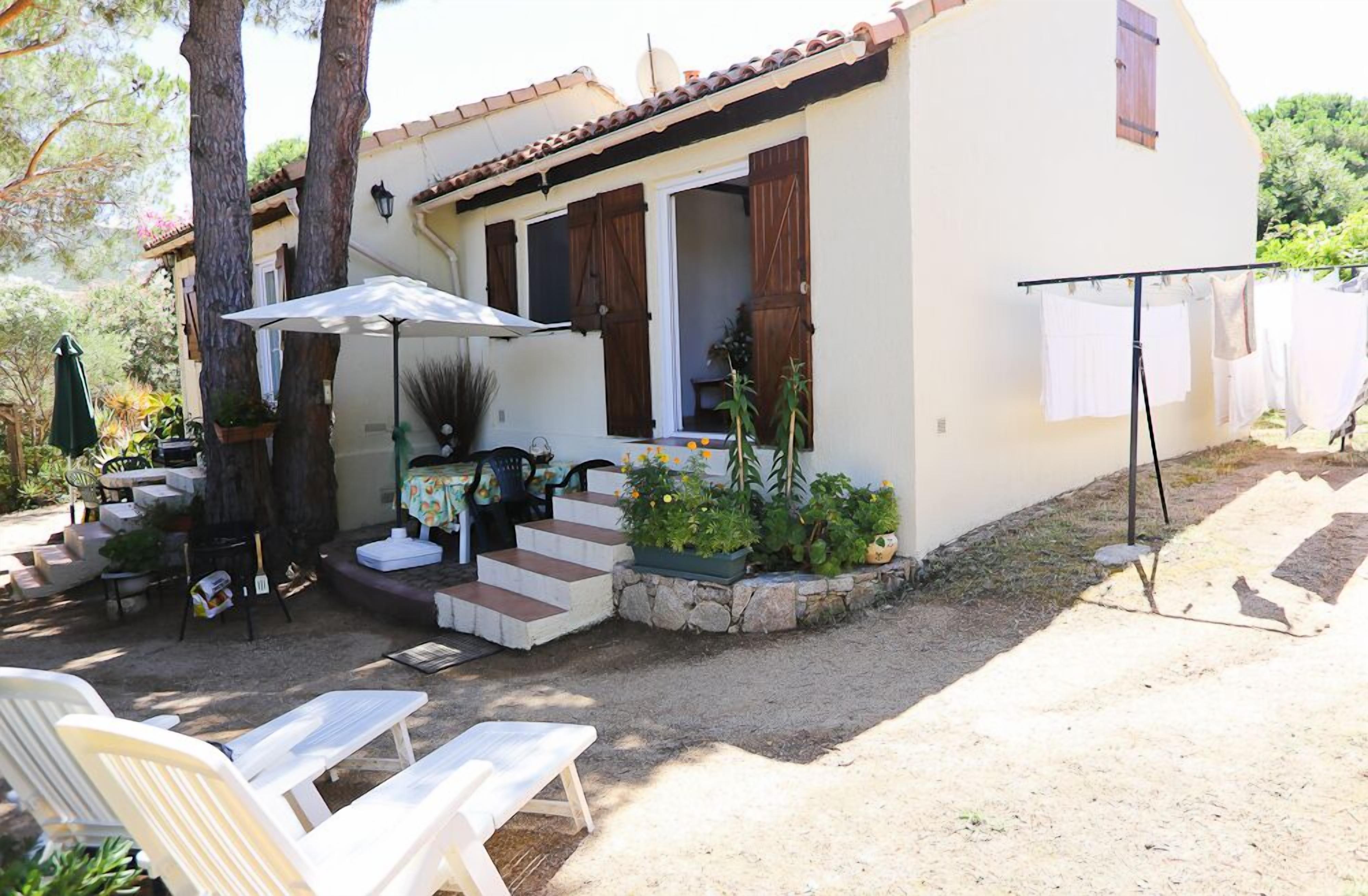 A house with a patio area, outdoor seating, and a clothesline.