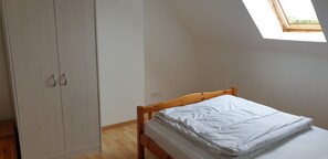 Cozy retreat with a wooden bed, wardrobe, and natural light from the skylight.