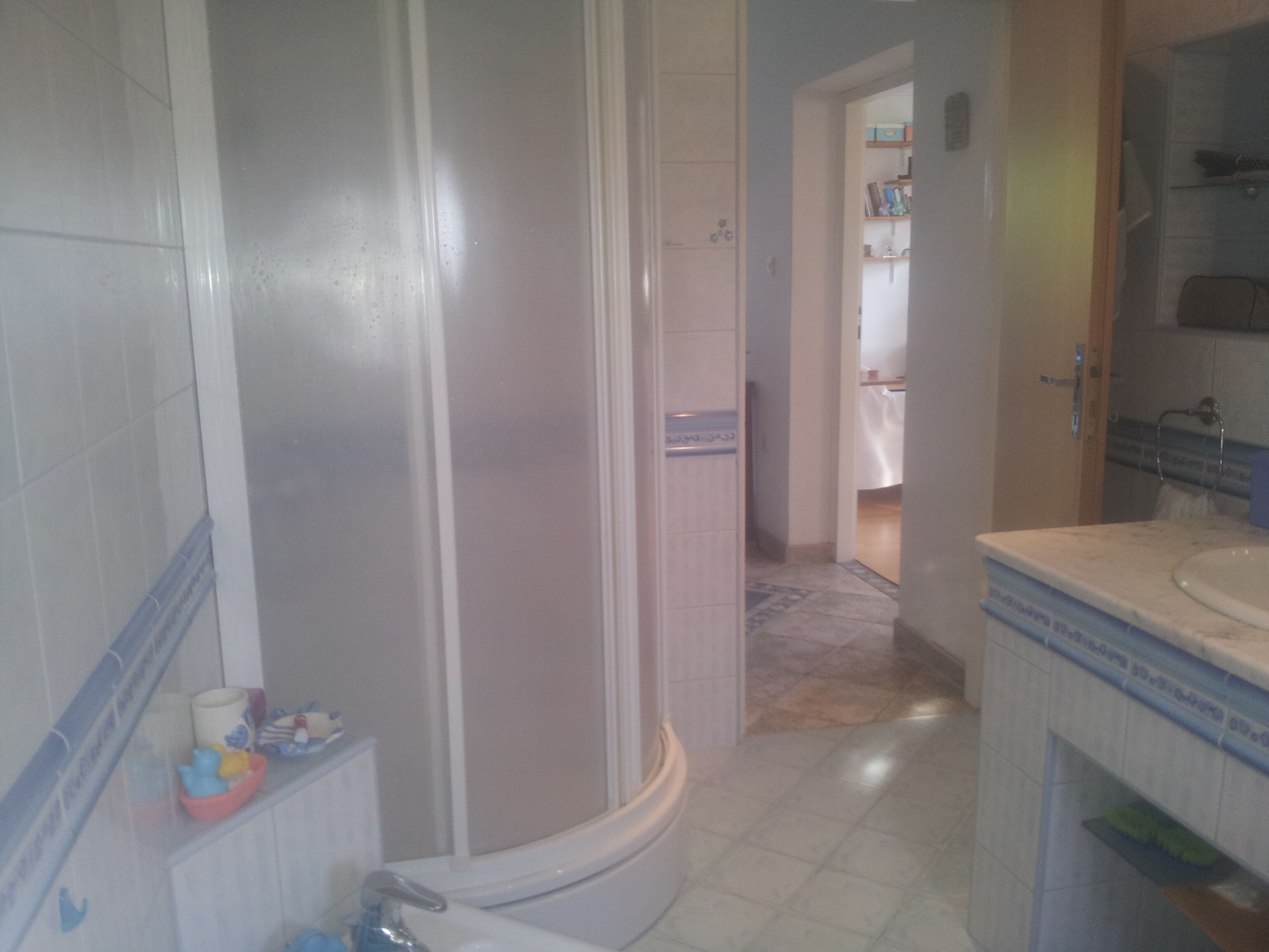 A bathroom with a shower, toilet, and sink.