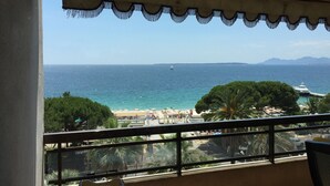 Ein Balkon mit Blick auf das Meer, den Strand und ferne Berge.