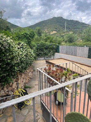 Un jardin sur le toit, agrémenté d’un mur en pierre, d’une rambarde en métal et de différentes plantes.