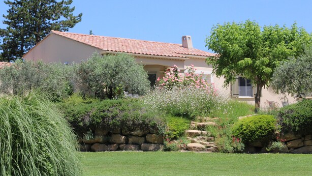 A house with a red-tiled roof, surrounded by a well-maintained garden with various plants and a stone wall. - Mazan holiday villa with private swimming pool on 3000m (Mazan)