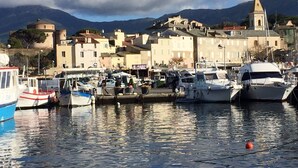 Un port de plaisance avec des bateaux amarrés, une église dotée d’un clocher et des bâtiments en arrière-plan.