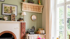 A dining area with a brick fireplace, a wooden bench, and a table set for dining.