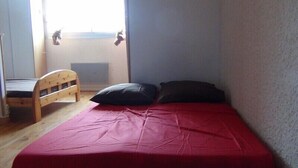 A small room with a single bed, a wooden chair, and a window. - Large first floor studio in a peaceful building: no smoking, pets not allowed (Les Rousses)