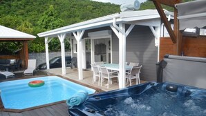 A deck with a hot tub, a pool, and outdoor furniture. - THE FLAMBOYING VILLA at the estate "LES LODGES DE MALENDURE" (Bouillante)