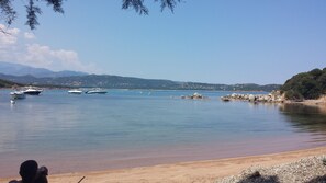 A beach with boats, clear water, and a mountainous backdrop. - One-bedroom apartment, first floor, private parking, air-conditioned bedroom and living room (Corte)