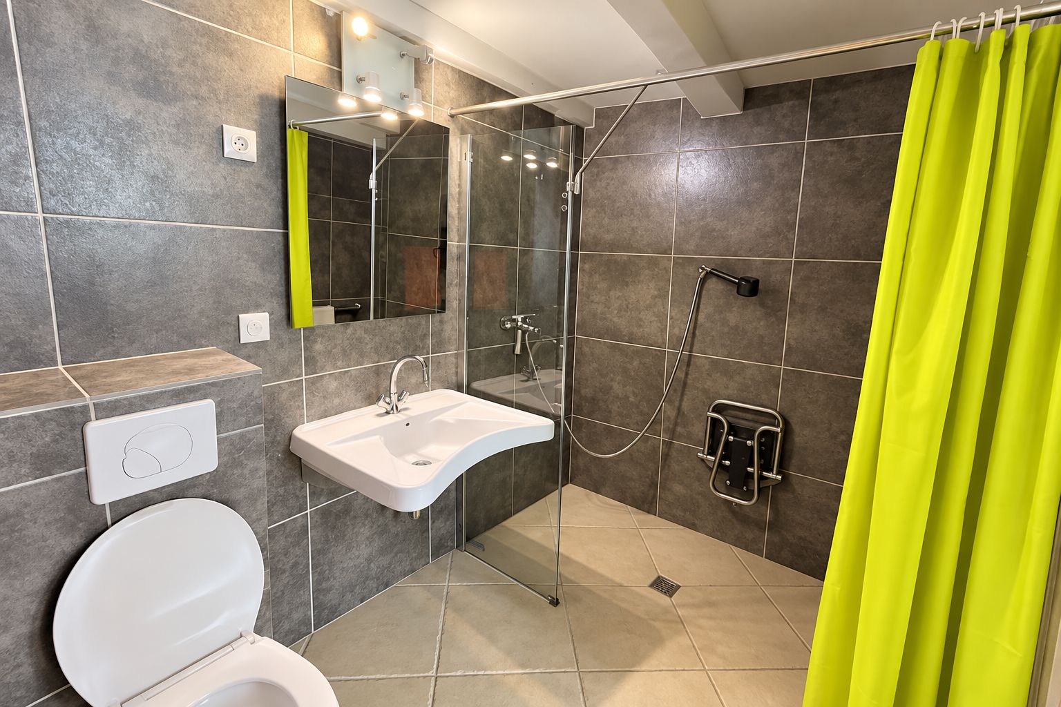 Un baño moderno con ducha, lavamanos e inodoro.