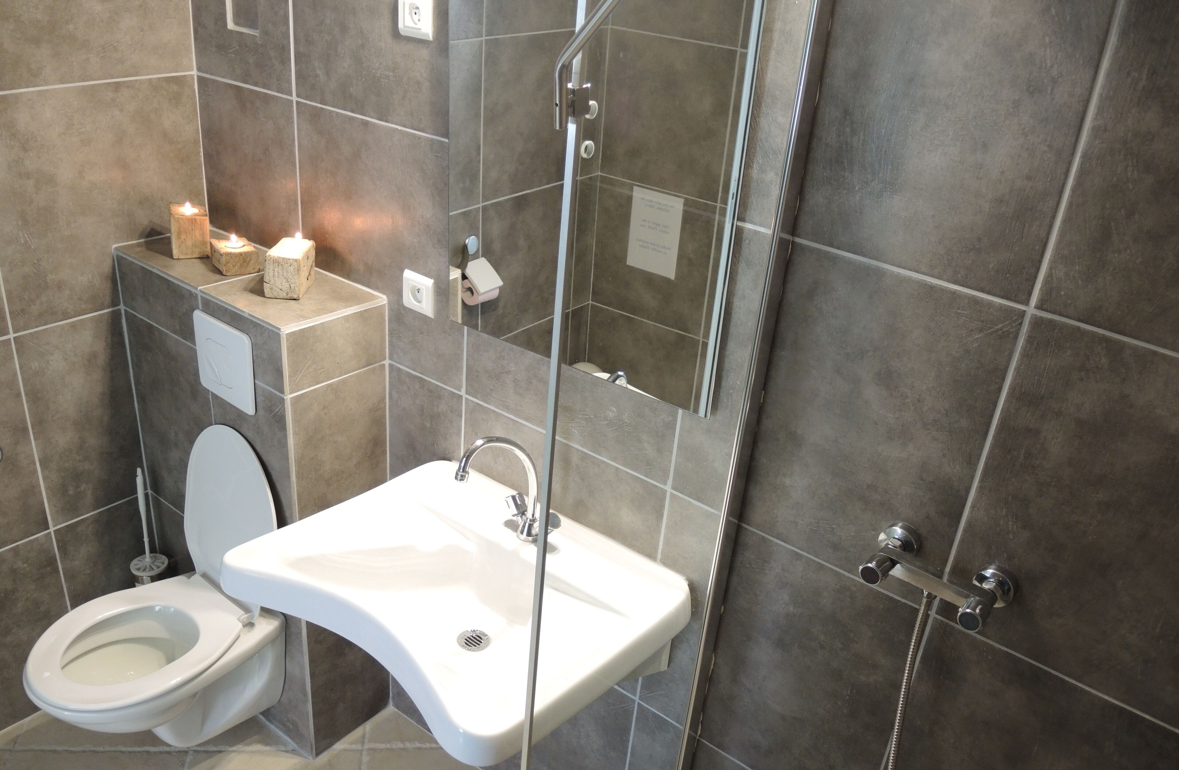 Une salle de bain moderne équipée de toilettes, d’un lavabo et d’une douche.