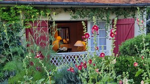 A cozy house with a garden full of flowers and plants.