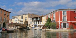 A canal with buildings on either side, a bridge, and boats. - Stunning ocean view in Les Issambres, pool, air conditioning, pétanque court, wheelchair accessible... (Roquebrune-sur-Argens)