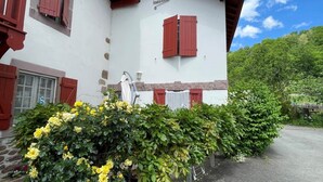 A white building with red shutters and a sign reading "ARREXENIA".
