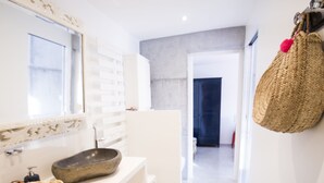 A modern bathroom with a white vanity, a large mirror, and a woven basket. - THE DUNE VILLA PLATIN ST PALAIS SUR MER (Saint-Palais-Sur-Mer)