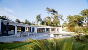 A modern house with a deck, outdoor seating, and a swimming pool. - THE DUNE VILLA PLATIN ST PALAIS SUR MER (Saint-Palais-Sur-Mer)